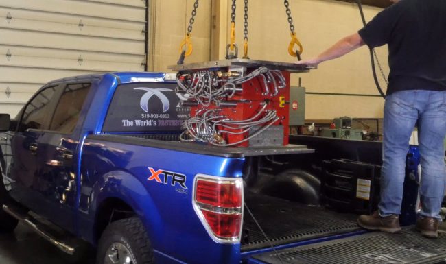 Plastic injection mold being loaded into the back of an XMD-branded Ford Pickup truck